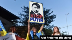 Плакат на акції підтримки України із зображенням президента РФ Володимира Путіна під час візиту до Південно-Африканської Республіки керівника МЗС Росії Сергій Лаврова. Преторія, ПАР, 23 січня 2023 року 