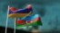 Armenian and Azerbaijani flags flutter in the wind against the evening sky.