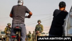 تصویر آرشیف: سربازان اسرائیلی در برابر دو تن از فلسطینی ها 