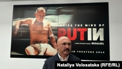 Польський режисер Патрик Вега на тлі афіші з зображеним у підгузку головним героєм біографічного фільму про російського лідера, Варшава, 5 лютого 2024 року