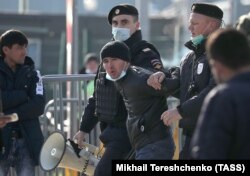 Москвада куч ишлатар тизим ходимлари олиб кетаётган мигрант. Архив.