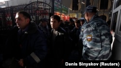 Мигранттарды акмалап турган орусиялык полиция кызматкери. Архивдик сүрөт.