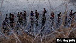 Иммигранты пересекают пограничную реку Рио-Гранде