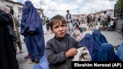A woman and boy beg for alms outside a mosque during Ramadan in Kabul. (file photo)
