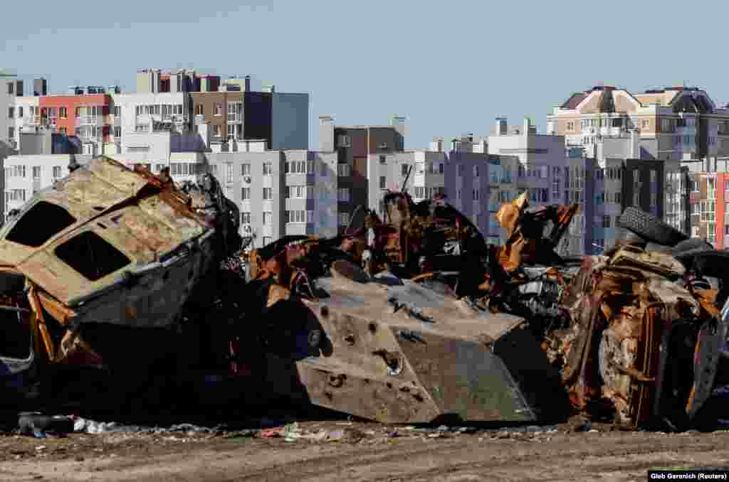 Mașini civile și vehicule militare distruse în timpul invaziei încă mai pot fi văzute în apropierea clădirilor de apartamente reparate din Bucea înainte de prima aniversare a eliberării sale.