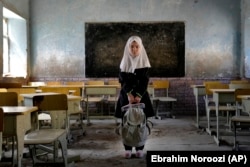 Mahtab, an 8-year-old Hazara student, poses for a photo in her classroom at the Abdul Rahim Shaheed School in Kabul days after a bombing attack in April 2022.