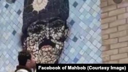 یوه ویډیو کې ښکاري چې دوه ځوانان په تورخم کې د امان‌الله خان پر عکس لګول شوی تور رنګ پاکوي.