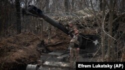 Український військовий дивиться, чи немає в небі російських БПЛА, на позиціях поблизу Бахмута, 25 березня 2024 року