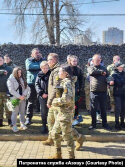 Захоронення праху бійця та ідеолога «Азову» Миколи Крука. Урну несе його дружина Ольга. Березень 2023 року