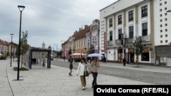 Turiști în centrul Turzii, renovat cu proiecte finanțate cu bani UE, ca parte a Planului de Mobilitate Urbană Durabilă.