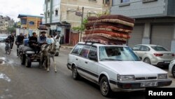 د اسراییلو د تخلیې له خبرداري وروسته یو شمېر فلسطینیان خپل ماشومان او مالونه په موټرو او خرګاډو کې له رفح څخه لېږدوي.