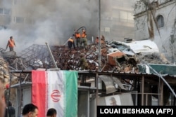Emergency and security personnel extinguish a fire at the site of a suspected Israeli air strike against the Iranian Consulate in Syria's capital, Damascus, on April 1.