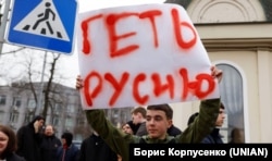 Юноша с плакатом у входа на территорию Киево-Печерской лавры, помещение которой, согласно решению властей Украины, должна была покинуть УПЦ (МП). Киев, 31 марта 2023 года