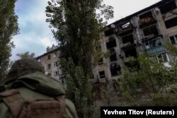 Поліцейський біля зруйнованої російськими атаками багатоповерхівці в Авдіївці, 17 жовтня 2023 року