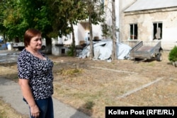 Svitlana Hinzhul in front of her home. Her yard is still full of her neighbors’ possessions, stacked under tarps for safekeeping in her care