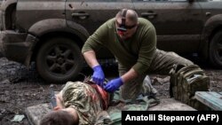 Un paramedic militar tratează un soldat ucrainean rănit în luptele de stradă cu forțele rusești, în orașul de pe linia frontului Bahmut, regiunea Donețk, 23 aprilie 2023.