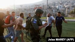 Ізраїльські сили безпеки та медики перевозять поранених із місця, де, як повідомляється, був завданий удар по стадіону на Голанських висотах, 27 липня 2024 року