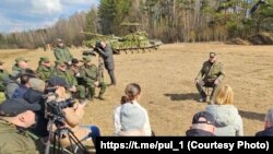 Аляксандар Лукашэнка сядзіць на табурэце на вайсковым палігоне, 2022