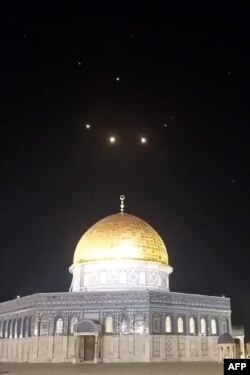 O imagine capturată dintr-un videoclip realizat la începutul zilei de 14 aprilie 2024 arată trasee de rachete pe cer de deasupra complexului Moscheea Al-Aqsa din Ierusalim.