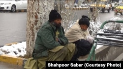 دو کارگر روزمزد در انتظار پیدا شدن کاری در گوشه‌ای از شهر هرات در یک روز سرد زمستان نشسته اند. 