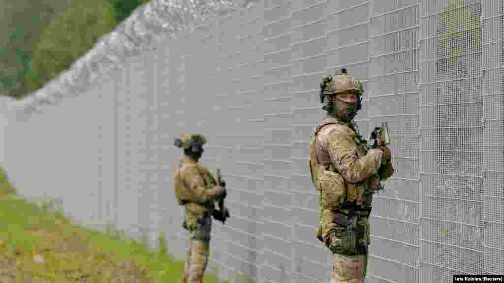 Співробітники спецпідрозділу Державної прикордонної служби Латвії патрулюють білоруський кордон вздовж огорожі поблизу Робезнієкі. Рига звинуватила білоруські сили безпеки в тому, що вони пошкодили прикордонний паркан і дозволили чотирьом мігрантам незаконно перетнути кордон. Влада Латвії назвала це &laquo;черговою провокацією&raquo;