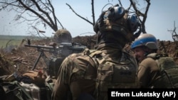 Украински войници обстрелват руски позиции от окоп на фронтовата линия в района на Запорожието, юни, 2023 г.