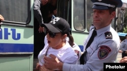 Armenia - A police officer uses force against a protester blocking a street in Yerevan, April 25, 2024.