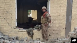 د پاکستان یو سرتېری د ډېره اسماعیل خان تر برید وروسته د ودانۍ له یوې برخې سره ولاړ دی - د ډېسېمبر ۱۲مې انځور.