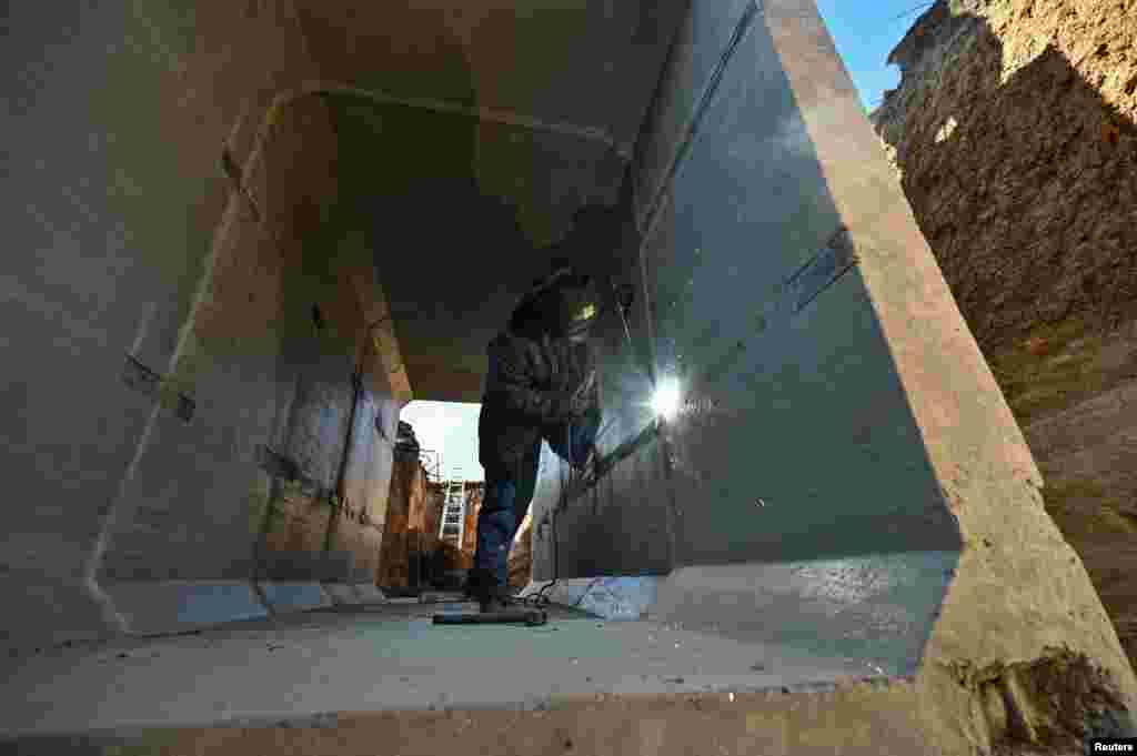 Зварник працює всередині бетонного укріплення. Запорізька область, 11 березня 2024 року