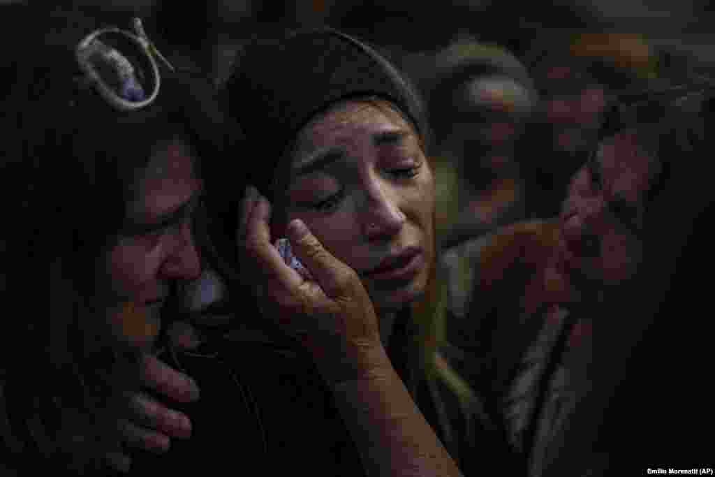 At a funeral in Bucha on August 31, 2022, Anastasia Ohrimenko, 26, is comforted by relatives and friends as she mourns the loss of her husband, Yuriy Styhlyuk, a Ukrainian soldier who died in combat.