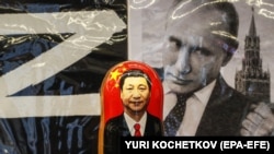 Російська матрьошка з портретом голови Китаю Сі Цзіньпіна перед фотографією очільника Росії Володимира Путіна у сувенірній вуличній крамниці в центрі Москви, 20 березня 2023 року