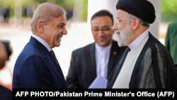 وزیراعظم شهباز شریف (کیڼ لوري ته) له ایراني ولسمشر ابراهیم رییسي سره ستړي مه شي کوي - د اپرېل ۲۲مې انځور.