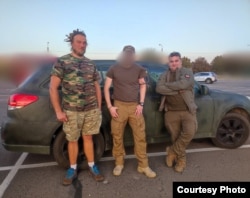 Передача автомобіля польському добровольцю «Фалькону» - командиру групи у складі Міжнародного легіону. На фото «Фалькон» (посередині) з пораненням руки, постріл здійснив снайпер. Це друге поранення польського добровольця