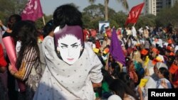 په کراچۍ کې د ښځو نړیوالې ورځې په مناسبت یوې ښځې د قندیل بلوڅې ماسک لګولی دی - د ۲۰۱۸ز کال انځور.