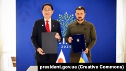 Президент України Володимир Зеленський і прем’єр-міністр Японії Фуміо Кішіда (ліворуч) під час церемонії підписання двосторонньої безпекової угоди між країнами. Італія, 13 червня 2024 року 