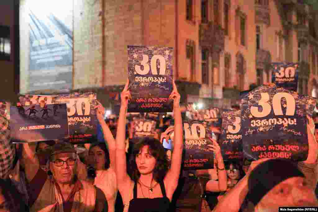 Protestatarii poartă pancarte pe care scrie &bdquo;Da Europei&rdquo; și &bdquo;Nu legii rusești&rdquo;.