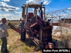 In Posad-Pokrovske, Tolik Ponomarenko shows off his tractor with the front wheels blown apart and the engine wide open after it ran over an anti-tank mine.