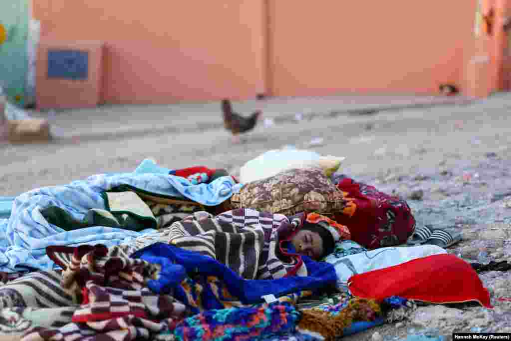 در این تصویر دیده می شود که شماری از کودکان در بیرون از خانه در روی زمین پس از زلزله در قریه مولای براهیم خوابیده اند عکس از رویترز