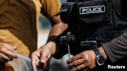 د کراچۍ یو پولیس د یو برید له ځایه شواهد ټولوي - پخوانی انځور.