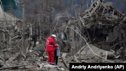 Медичний працівник втішає жінку на місці російського авіаудару, Запоріжжя, 22 березня 2024 року