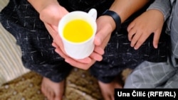 Jan Mohammad Habibi sa jednom od kćerki pije čaj od šafrana u izbjegličkom stanu u Nirnbergu u kojem su smješteni nakon bijega iz Afganistana. Septembar 2023.
