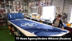 Шивачката Тове Лике изработва знаме на НАТО в работилница край Стокхолм, Швеция. 