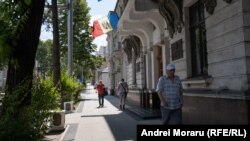 Trecători în preajma clădirii Curții Supreme de Justiție de la Chișinău, iulie 2023