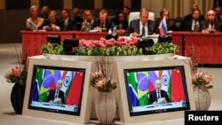 Министърът на външните работи на Русия Сергей Лавров присъства на пленарната сесия, докато руският президент Владимир Путин говори във видеовръзка на срещата на върха на БРИКС на 28 април 2023 г. в Южна Африка.