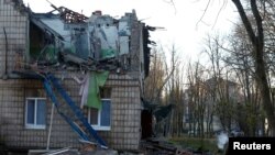 În imagine, un polițist inspectează clădirea unei grădinițe avariate în urma atacului armatei ruse asupra Kievului.