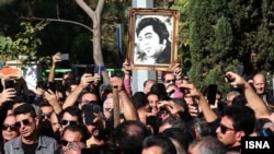 تششیع‌کنندگان پیکر گلپا عکسی از دوران جوانی او را به دست گرفته‌اند