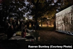 Зрители гледат изображения, които показват квартала "Уранус", преди да бъде разрушен.