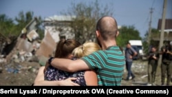 Люди втішають один одного після російського обстрілу, Дніпропетровська область, 26 серпня 2024 року