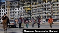 Робітники на тлі будівництва багатоповерхівки в окупованому Маріуполі. Ілюстративне фото