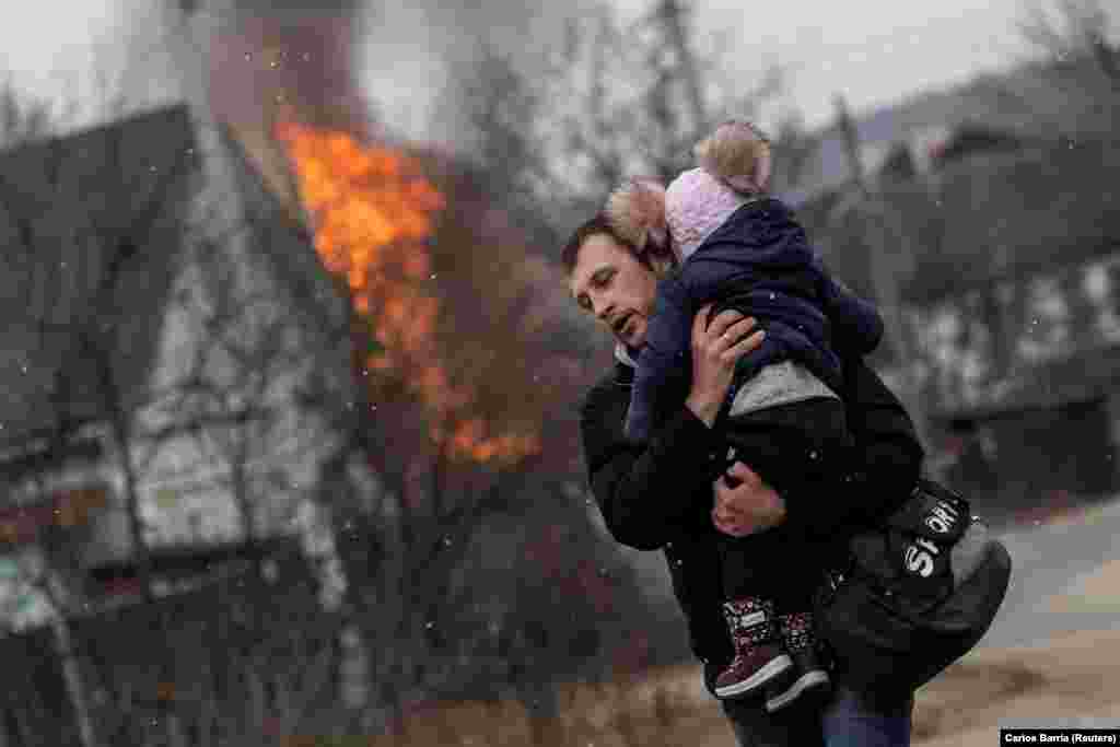 A man carries a child from the town of Irpin after heavy shelling as Russian troops advanced toward Kyiv on March 6, 2022.